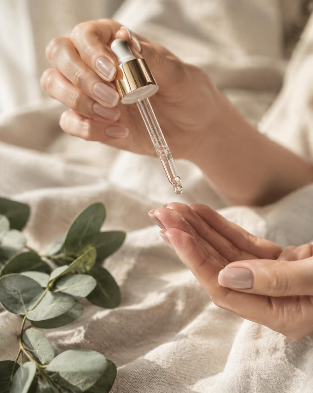 Mãos aplicando o Glow Serum